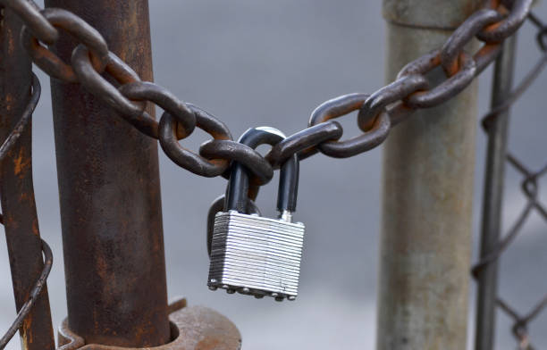 Chained and padlocked metal chain link fence.