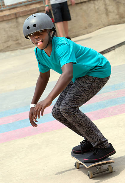 teenager boy skateboarding auf seinem skateboard - extreme skateboarding action balance motion stock-fotos und bilder