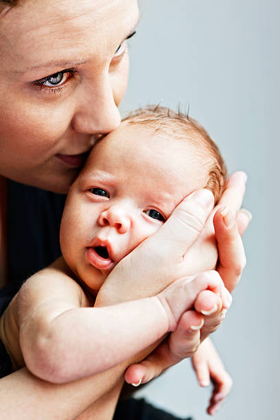 мать держит ее новорожденного ребенка мальчик - mother baby new kissing стоковые фото и изображения