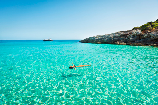 Idyllic holidays: girl floating in fresh clean turquoise water.