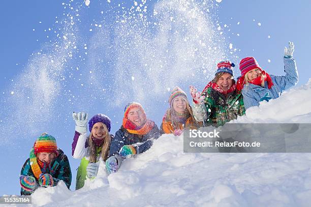 Grupo De Gente Feliz Acostado De Hill Jugando Con La Nieve Foto de stock y más banco de imágenes de Actividad después de esquiar