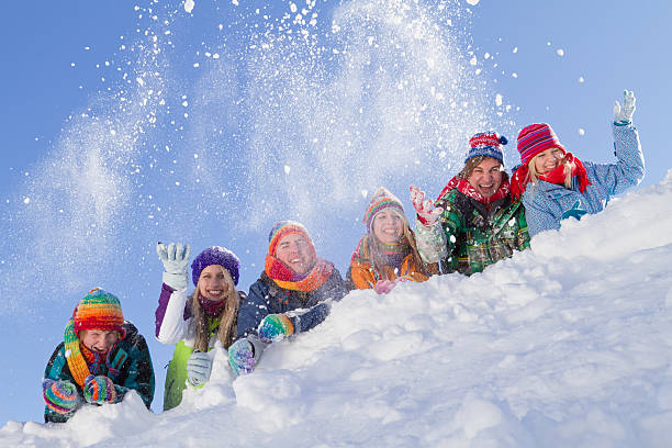 istock Group of happy people lying on hill playing with snow 155351164
