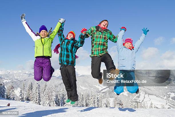 Quattro Giovani Multicolore Vestiti Salto Sulla Neve - Fotografie stock e altre immagini di Saltare