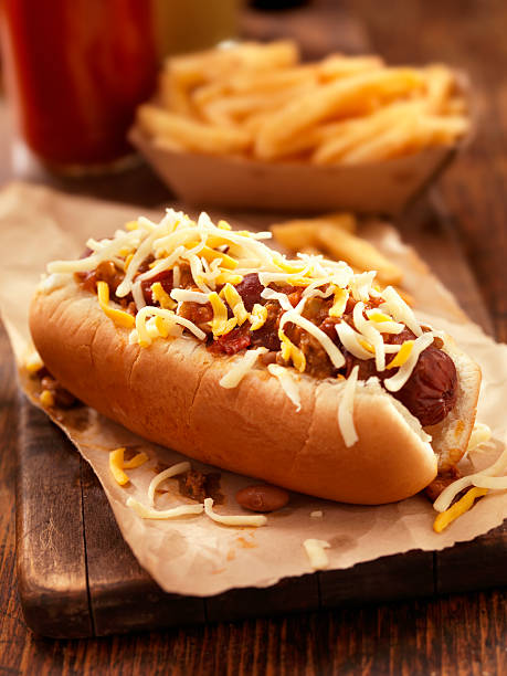 chili-cheese-hotdog - cheese focus on foreground on top of portion stock-fotos und bilder