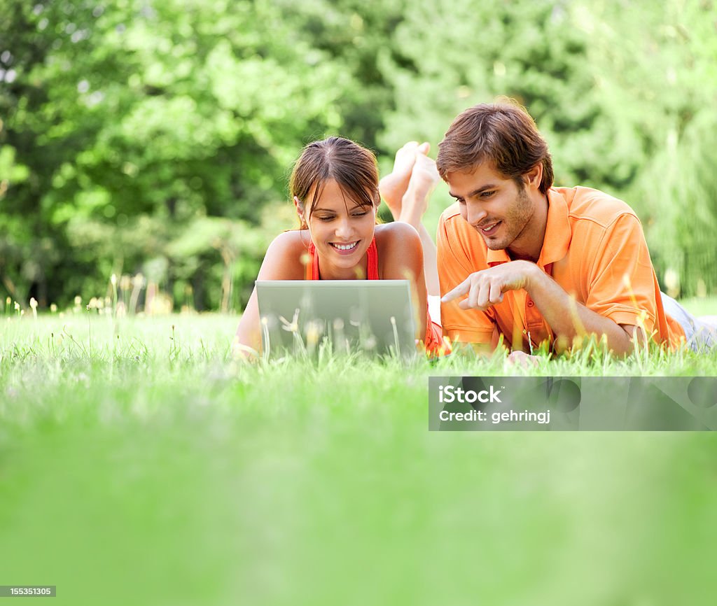 Jeune couple à l'aide d'ordinateur portable, en plein air - Photo de Activité de loisirs libre de droits