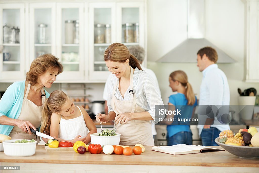Passing on family recipes Mother and grandmother help their daughter to make salad Active Seniors Stock Photo