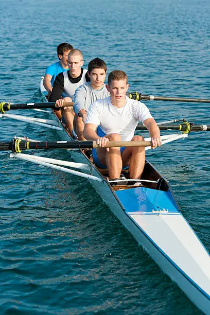 Front view of male four-seated scull rowing team