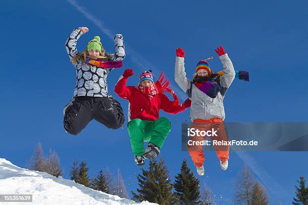 Три Молодых Людей В Зимней Одежде Прыгать Спуск На Снегу — стоковые фотографии и другие картинки Прыгать