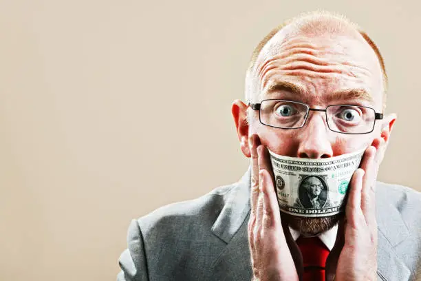 Photo of Terrified businessman tries to remove dollar bill gag