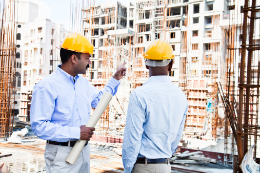 engineer and architect on cconstruction site in India, dicussing plans