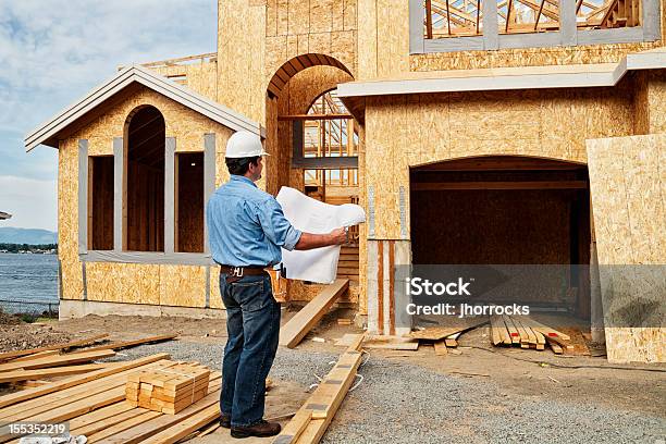 Trabajador De Construcción En Sitio Con Los Planes Foto de stock y más banco de imágenes de Trabajador de construcción