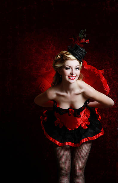 Burlesque woman in red holding feather fan Retro styled. pin-up burlesque blond woman in red/black costume with hat. She's leaning forward holding a read feather fan behind her back. vintage of burlesque dancers stock pictures, royalty-free photos & images