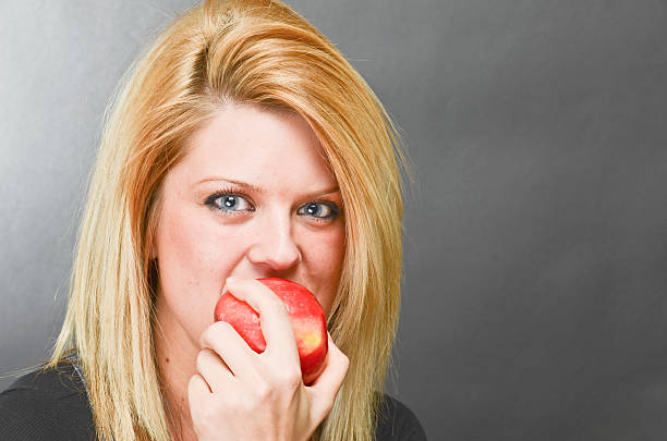 istock Healthy young woman eating an apple 155352433