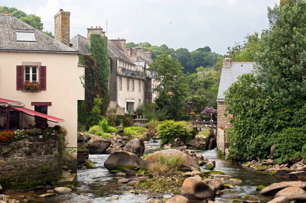 View of the river at low tide running through the romantic village Pont-Aven, a famous tourist resort in Brittany, France.