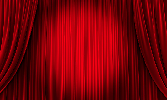 close up view of dark black in thin and thick vertical folds made of black out sackcloth fabric, panoramic view. grey curtain background with yellow spotlight at center in theater or cinema.
