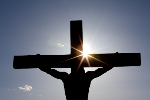 A silhouette of Christ on the cross. Easter theme. Horizontal colour image. Sunset. Flare. This image of the crucifixion is a powerful statement of Jesus and his love for mankind. The redemptive power of the cross is the central theme of Christianity and the Christian religion. 