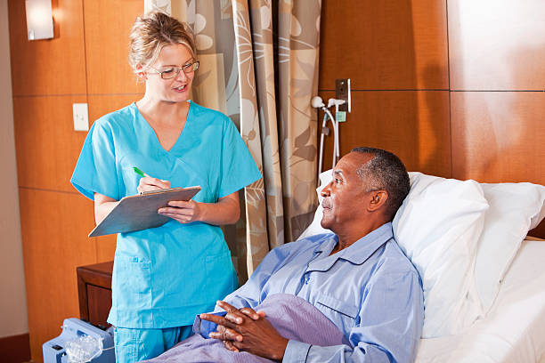 infermiera parlando con il paziente in ospedale letto - sc0527 foto e immagini stock