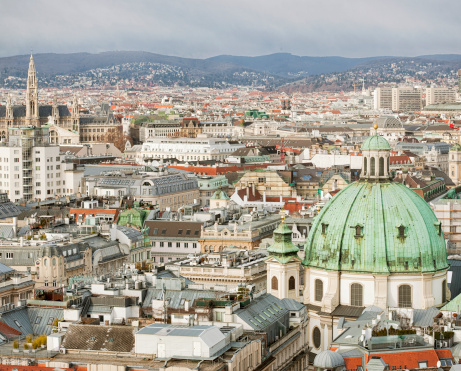 High angle view of Vienna, taken from St. Stephen's Cathedral.  The green dome of St. Peter's Church (Peterskirche) is visible in the foreground, and the spire of the Rathaus (City Hall) in the distance to the left.