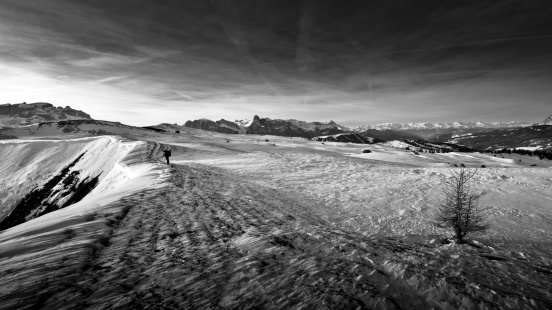 A hiker on a ridge and a boundless landscape (Alta Badia, Dolomites, italian Alps).