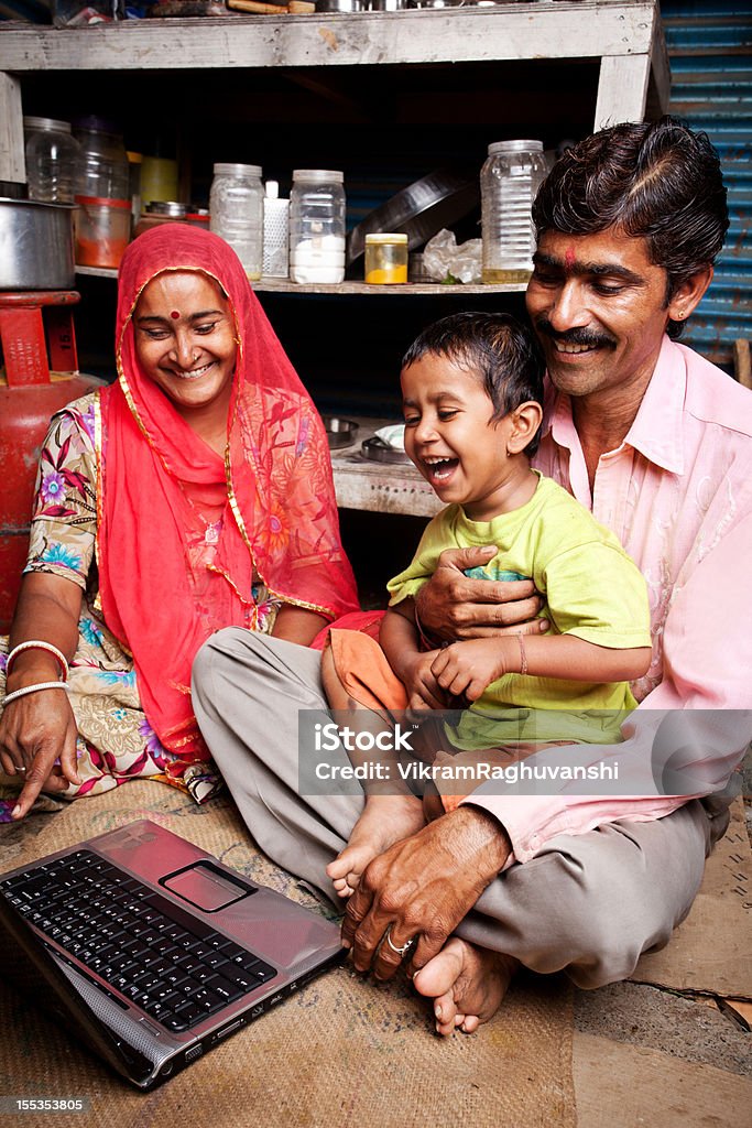 Веселый Раджастана сельских районах Индийского мать отец и сын, используя ноутбук - Стоковые фото Ребёнок роялти-фри