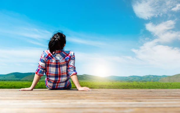 istock Woman sitting on wooden sidewalk 1553542174