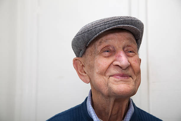 Senior male 90 years old wearing grey herringbone flat cap stock photo