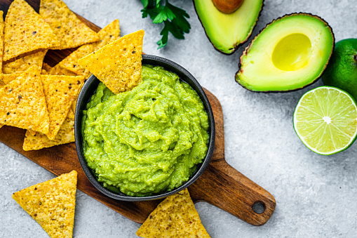 Mexican food: guacamole and nachos shot from above on gray table. High resolution 42Mp studio digital capture taken with Sony A7rII and Sony FE 90mm f2.8 macro G OSS lens