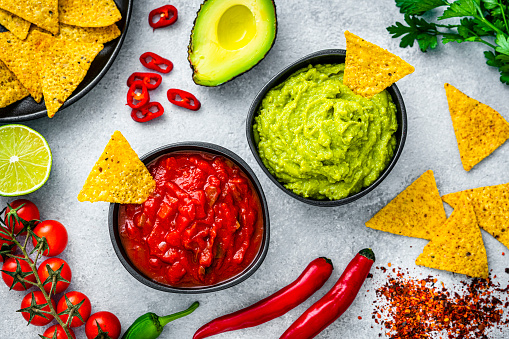 Traditional Mexican salsa sauce, guacamole and nacho chips shot from above. High resolution 42Mp studio digital capture taken with Sony A7rII and Sony FE 90mm f2.8 macro G OSS lens