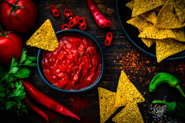 istock Salsa sauce and nacho chips shot from above on dark wooden table 1553543366