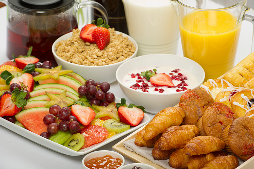 Fruit platter, assorted baked goods, yoghurt and muesli with orange juice,milk, coffee and tea