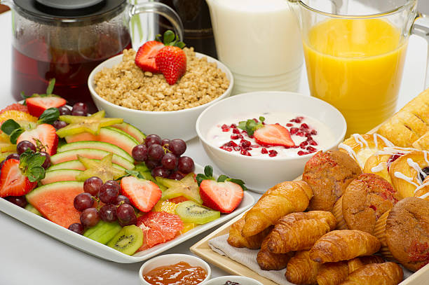 A healthy continental breakfast buffet Fruit platter, assorted baked goods, yoghurt and muesli with orange juice,milk, coffee and tea continental breakfast photos stock pictures, royalty-free photos & images