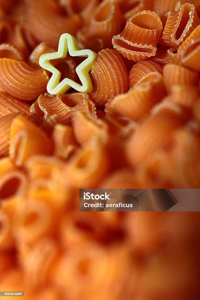 Star among pasta Star shaped pasta on a tomato colored pasta background, shot in an industrial pasta manufacturing plant. Backgrounds Stock Photo