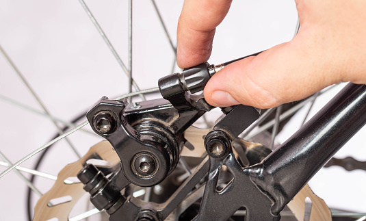 Adjusting the tension of the bicycle brake caliper cable. Brake setting. Copy space for text