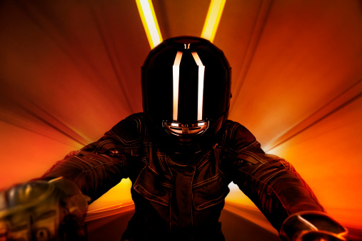 Close-up of a biker riding through a tunnel. Some grain visible.