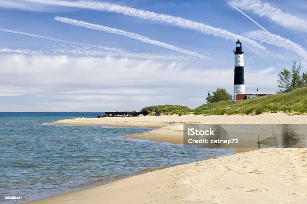 Lighthouse and Beach in Summer with Dramatic Sky Background Lighthouse and beach under dramatic summer sky, a Lake Michigan state park in Ludington, MI, USA. Michigan Stock Photo