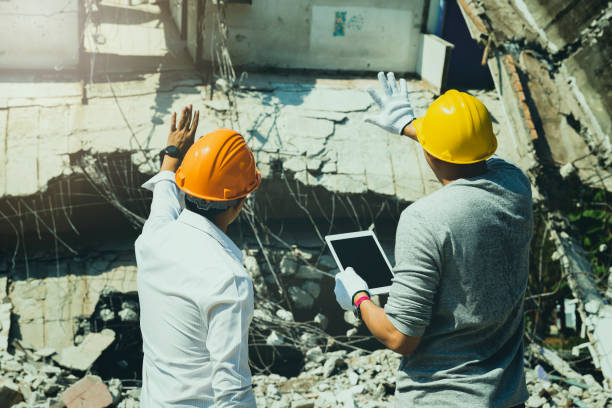 istock Demolition control supervisor and contractor discussing on demolish building. 1553560421