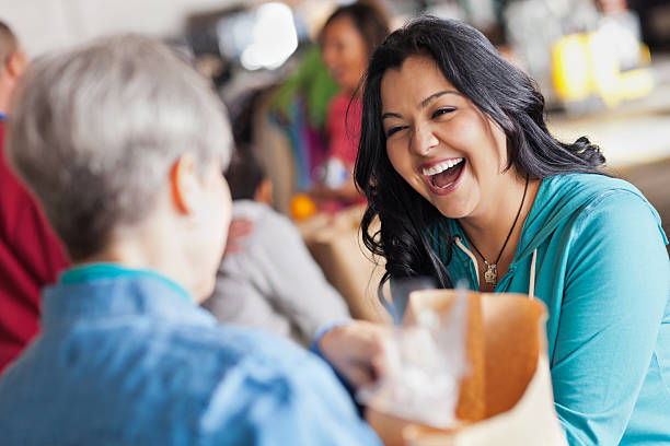 istock Young woman laughing with someone while handling food 155357136