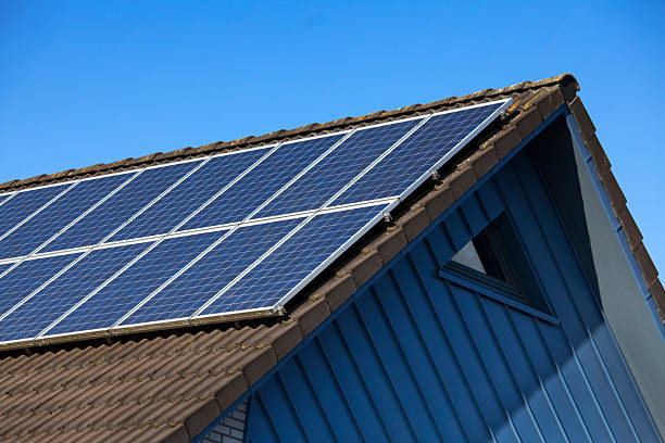 panel słoneczny na szczyt dachu przeciw błękitne niebo - solar panel zdjęcia i obrazy z banku zdjęć