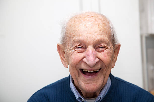 Senior adult male laughing portrait; he is 90 years old Senior adult male portrait; he is 90 years old. In front of his out of focus white kitchen wall. 90 plus years photos stock pictures, royalty-free photos & images