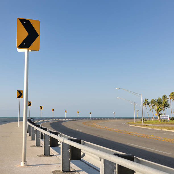 roosevelt boulevard key west, florida, stati uniti - crash barrier road arrow sign palm tree foto e immagini stock