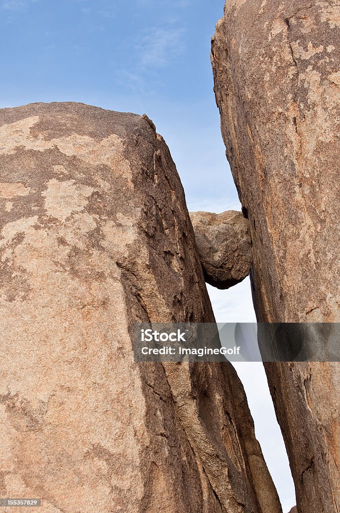 Boulder presentato in Cliff - Foto stock royalty-free di Intrappolato