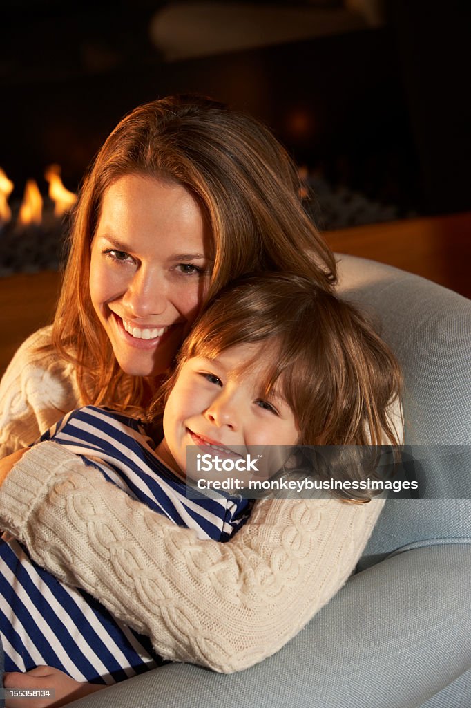 Ritratto di Madre e figlio seduto davanti al fuoco - Foto stock royalty-free di Caucasico
