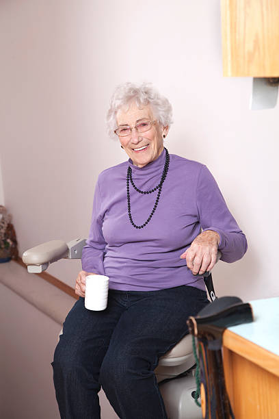 istock Elderly woman using stairlift: assisted living 155358216
