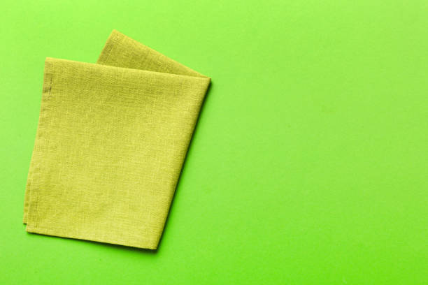 istock top view with green kitchen napkin isolated on table background. Folded cloth for mockup with copy space, Flat lay. Minimal style 1553583403