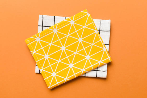 istock top view with yellow empty kitchen napkin isolated on table background. Folded cloth for mockup with copy space, Flat lay. Minimal style 1553583409