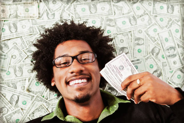 istock Blissfully happy young man with lots of dollars 155358343