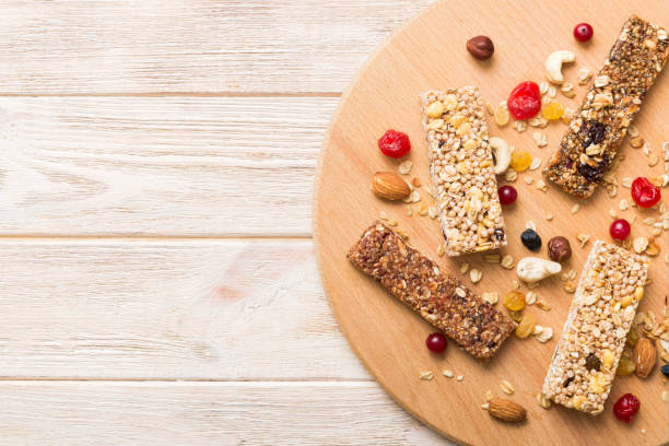 istock Various granola bars on table background. Cereal granola bars. Superfood breakfast bars with oats, nuts and berries, close up. Superfood concept 1553584038