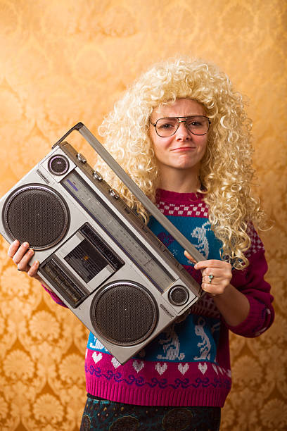 Goofy 1980s teenager holding boombox Vertical portrait of a nerdy 1980s teenager holding a boombox (ghetto blaster) nerd sweater stock pictures, royalty-free photos & images