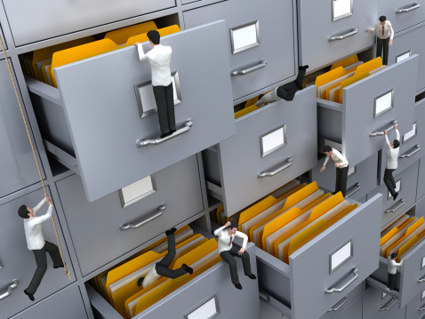3D businessman figures searching inside the file containers looking for needed folders and documents. 