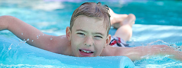 istock Boy Floating on Air Mattress in Backyard Pool 155359249